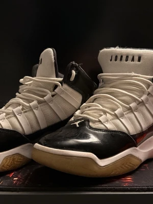 Nike Jordan 11 sneakers svart/vit - Snygga Nike Jordan 11 sneakers med vit ovandel, svarta lackdetaljer och gummisula. Klassisk JORDAN-logga på plösen och ikonisk design. Perfekta för dig som gillar streetwear och basketstil.