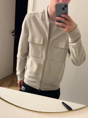 Beige overshirt från dressman - Snygg beige overshirt med två stora bröstfickor och dragkedja framtill. Rak passform och stilren design som passar perfekt till många olika outfits. Tillverkad i mjukt material för skön känsla.