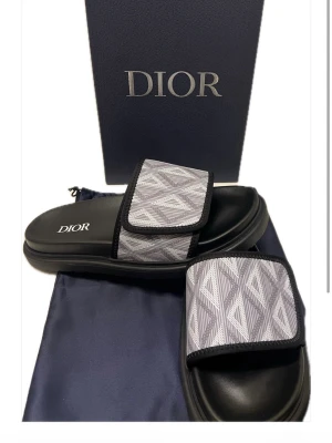 DlOR sandlas - Skick:Ny Storlek: 41 (passar 42-43) Färg:Svart/Blå Box, Dustbag&Veriferingskort följer med ✅  Postar inom 24h 📦 Snabb leverans 🚚  Finns att hämta i Stockholm📍