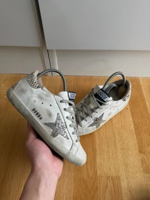 Golden goose skor - Hej, säljer nu dessa otroligt snygga Golden goose skor. | Skorna är i bra skick men har en defekt där bak som visas på bilden. | Inget som påverkar eller syns så mycket. Lite slitna skosnören.| Väldigt snygg färg som passar till allt. | Hör av er vid frågor!🌟