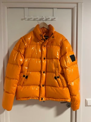 Peak Performance Jacka - Peak Performance Jacka X.8 Apres i orange. Endast använd en gång. Går att ta av armarna för att kunna ha den som en väst! Nypris ca 6000kr.  Yttertyg är 100% polyamid. Fyllningen är gjord av 90% gåsdun och 10% gåsfjädrar.