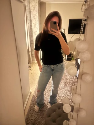 Bootcut jeans från Nelly ljusblå - Säljer ett par ljusblå bootcut jeans från Nelly med slitna detaljer på knäna. Jeansen har klassisk femficksmodell, låg midja och är tillverkade i mjukt denimtyg. Perfekta för dig som gillar en avslappnad och trendig look.