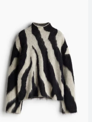 Beige och svart zebramönstrad stickad tröja - Säljer en fluffig stickad tröja med beige och svarta zebraränder. Tröjan har hög hals och långa ärmar, perfekt för dig som vill sticka ut med ett djuriskt mönster. Materialet är mjukt och ger en cozy vibe, passar dig som gillar statement-plagg.