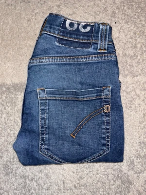 Blåa Dondup jeans skinny modell. - Säljer nu dessa Dondup jeans med skinny passform och snygga kontrastsömmar. Jeansen har en unik detalj på bakfickan och klassisk femficksdesign. Tillverkade i stretchigt denim för en bekväm känsla och sitter tajt längs benen. Lite mindre i strl. Vårt pris är prutbart🤝 Hör av er vid intresse/ frågor!