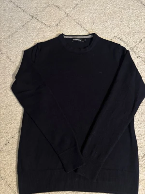 Mörkblå tröja J.Lindeberg - Mörkblå stickad tröja från J.Lindeberg med diskret logga på bröstet. Är S men sitter som xs. Hör av er om funderingar.