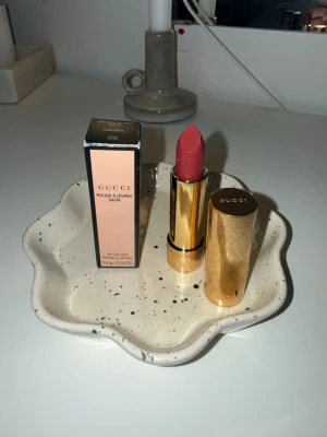 Gucci Rouge à Lèvres Satin läppstift - Gucci Rouge à Lèvres Satin – 202 Moira Sienna (NY)  Säljer ett helt nytt och oanvänt läppstift från Gucci. Modell: Rouge à Lèvres Satin Nyans: 202 Moira Sienna  Endast öppnad för bild, aldrig testad på läppar. Kommer med originalförpackning (se bilder).  Nypris i butik: ca 550 kr