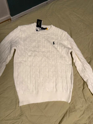 Vit kabelstickad tröja Polo Ralph Lauren - Säljer Ralph Lauren-tröjor eftersom jag har många hemma och inte vet vad jag ska göra med dem. Därför har jag valt att sälja dem billigt. För dig som vill ha en tröja av bra kvalitet. Vill sälja snabbt. Tröjorna är oanvända. Storleken är S