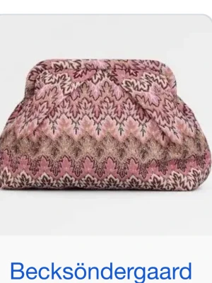 Mönstrad kuvertväska från Becksöndergaard - Supersnygg kuvertväska från Becksöndergaard med ett unikt mönster i rosa, beige och brunt. Väskan har en mjuk form och är tillverkad i ett tygmaterial som känns både trendigt och mysigt. Perfekt accessoar för att lyfta din outfit!