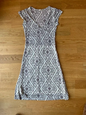 Knälång blommig klänning från Filippa K - Supersöt klänning från Filippa K med blommigt mönster. Superfint skick, inga skavanker. Har lite tunnare material men har dubbla lager tyg för att täcka mer. Den är V ringad med sömmar under bysten för en snygg passform.