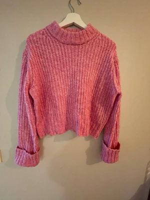 Mysig rosa stickad tröja M - Rosa stickad tröja från Pigalle i storlek M. Jag har aldrig använt den – fick den av någon annan. Väldigt mysig och trendig passform med uppvikta ärmar.