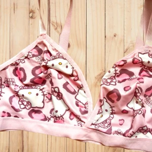 Söt BH med Hello Kitty-motiv! - Söt BH utan bygel med justerbara axelband i storlek M & Hello Kitty-motiv. Mått under byst: 78-81 cm. Ny och oanvänd.