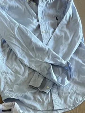 Ljusblå skjorta från Ralph Lauren - Klassisk ljusblå skjorta från Ralph Lauren med button-down krage och broderad logga på bröstet. .