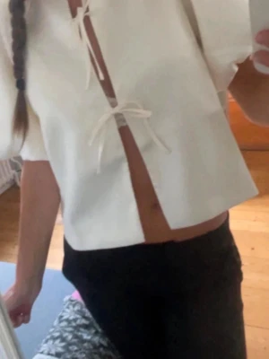 Blus med puffärmar (xs) - Säljer en vit blus från Neo Noir i ett glansigt material med korta puffärmar och två knyt framtill. Nyskick utan original förpackning eller prislapp.                              Slutsåld överallt!