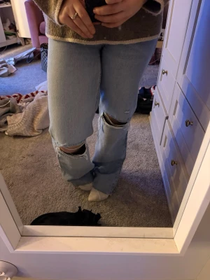 Ljusblå baggy jeans - Säljer ett par ljusblå jeans med raka ben och slitningar över knäna från Zara🤞🏽. Använder ej längre men så snygga!!! Pris kan diskuteras 