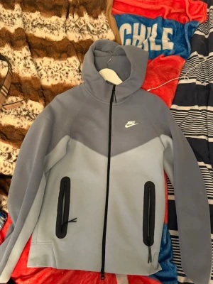 Nike ljusblå hoodie med dragkedja - Hej nu säljer jag min Nike kofta som ej passa mig längre. Säljer på grund av att jag har tränat nu ett tag och den har blivit liten för mig nu. Skick 9/10 den är som ny storlek xs. Skriv privat vid frågor eller mer bild.