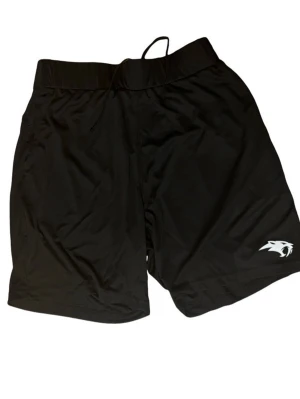 Svarta tränings-shorts - Svarta tränings-shorts 100% polyester. Shortsen har ficka och resorb som gör så att den sitter skönt över midjan.