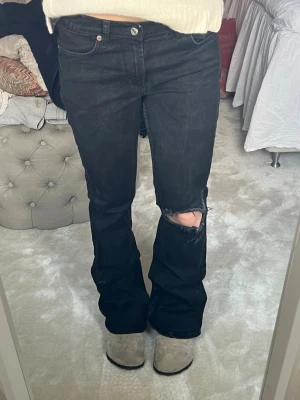 Låg midjade svarta jeans med hål - Snygga lågmidjade booutcut jeans med hål. Bra skick. Använda fåtal gånger. Stolek 36 