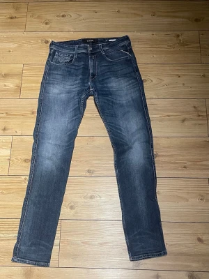 Replay Anbass jeans blå denim - Säljer ett par Replay Anbass jeans i klassisk blå denim med snygg tvätt och raka ben. Jeansen har fem fickor, tydliga sömmar och Replay-logga på bakfickan. Perfekt passform och tidlös stil för dig som gillar jeans med lite edge. Storlek 32/34