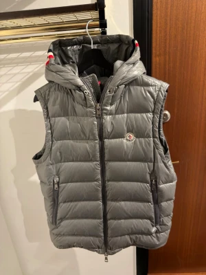 Moncler Lanoux Giler Hooded - Moncler Lanoux Gilet väst i bra skick fattas Snörerna samt har västen lite fläckar av regn behövs en tvätt. Självklart äkta en sällsynt modell.