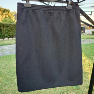 Svart ribbad långkjol - Säljer en svart långkjol med diskret ribbad struktur. Kjolen har rak passform och enkel design utan synliga detaljer. Perfekt för dig som gillar stilrena och klassiska plagg. Materialet känns mjukt och följsamt mot kroppen. Längd ca 57 cm