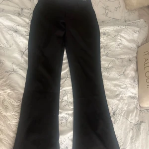 Svarta bootcut-byxor Gina Tricot  - Svarta bootcut-byxor från Gina Tricot i storlek S. Byxorna har ganska låg midja, booutcut form och snygga bakfickor med lock och knapp. Perfekta för dig som gillar en stilren look med lite edge. Materialet känns mjukt och följsamt. Skriv privat för fler frågor osv, de är slutsålda på hemsidan och de är i väldigt bra skick då jag tyvärr inte har kunnat använda de mycket pga att de är för stora för mig💗