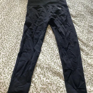 Svarta tight från AYBL, storlek L - Svarta tights från AYBL i storlek L. De är tighta och har en hög midja som sitter skönt och ger bra stöd. Materialet är stretchigt. Använda vid ett tillfälle.