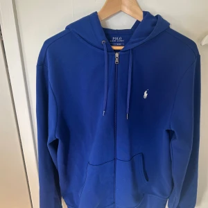 Blå hoodie från Polo Ralph Lauren - Snygg blå hoodie från Polo Ralph lauren.Ganska vällanvänd fast utan skador eller fläckar.