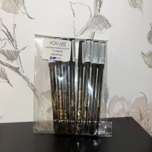 Svart eyelinerpenna från Vollare - Säljer ett set med 8 st eyeliner/kajalpennor från Vollare Cosmetics i färgen Black/Noir. Pennorna har en klassisk svart färg och är i trä med svart plasthylsa och guldtext. Perfekt för att skapa skarpa och intensiva linjer runt ögonen.