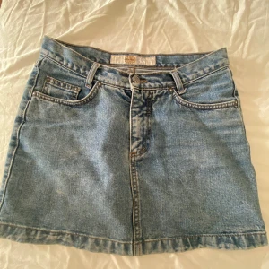 Blå jeanskjol från Mormaii - Säljer en klassisk blå jeanskjol från Mormaii i storlek 38. Medellång.