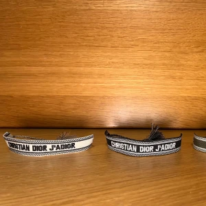 Christian Dior J'Adior armband - Säljer ikoniska Christian Dior J'Adior armband i vävd textil med broderad logga för 200kr. Finns i svart vit och grön. Justerbar knytning med tofsar i ändarna. Perfekt accessoar för att lyfta din outfit med lyxig känsla. Säljer för ett väldigt billigt pris skriv för fler frågor eller bilder. Armbanden är aldrig använda. Köp helst inte på köp nu för jag vill lägga upp en ny annons