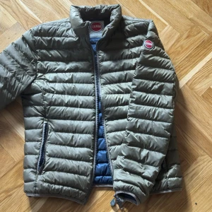 Olivgrön pufferjacka från Colmar - Säljer en olivgrön pufferjacka från Colmar. Jackan har dragkedja och två sidofickor med dragkedja.