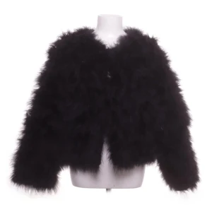 Svart pälsjacka från Dennis Maglic - Fluffig svart pälsjacka från Dennis Maglic med quiltat, glansigt foder. Jackan har lång ärm och en oversized look, perfekt för dig som vill sticka ut. Den är supermjuk och har en lyxig känsla med snygg struktur.