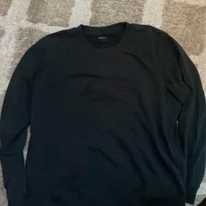 Svart sweatshirt från Newbody L - En stilren svart sweatshirt från Newbody i storlek L.har  En fettfläck på sig därav priset. men kan nog gå bort med nått bra medel