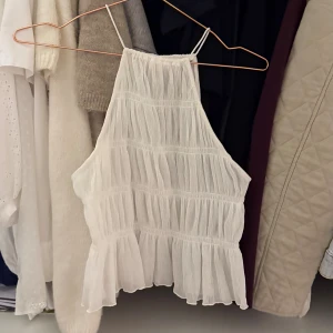 Vit topp - Vit topp från H&M i storlek xxs! Väldigt stretchig och luftig. Dock genomskinlig! Endast använd en gång🙌🏽