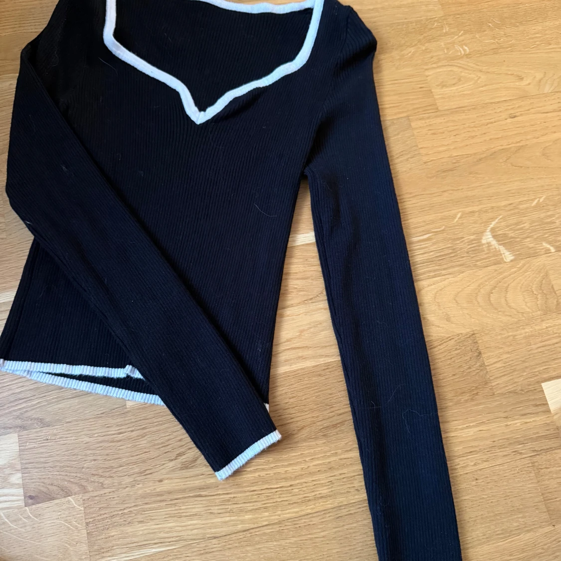 Svart ribbad långärmad topp med vit kant