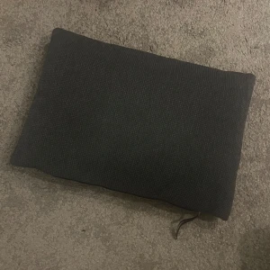 Mörkgrå prydnadskudde - Jättesöt mörkgrå prydnadskudde som är mönstrad på ena sidan och lent och har mjukt tyg på andra sidan. Finns en dragkedja så är möjligt att ta av kuddfodfalet och tvätta! Mått: 50x35. Använd gärna köp nu💕