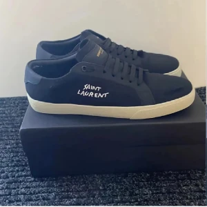 Svarta Saint Laurent sneakers - Säljer dessa väldigt populära saint Laurent skor. Dessa går och ha till allt skola, fest, jobbet osv… dem har blivit lite använda sen dessa bilder men tvättar dem helt och skickar med skolboxen och allt sånt. Har inte kvar kvitto och sånt för dem som vill sälja vidare men allt annat medföljer. Säljer till galet pris denna vecka då jag vill bli av med den så buda på!