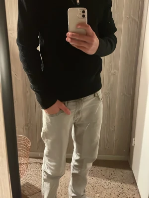 Svart ribbad half zip från Jack & Jones - Svart långärmad tröja från Jack & Jones med ribbad struktur och half zip i halsen. Tröjan har en stilren design med hög krage och är gjord i mjukt stickat material. Perfekt för dig som gillar enkel och snygg stil.