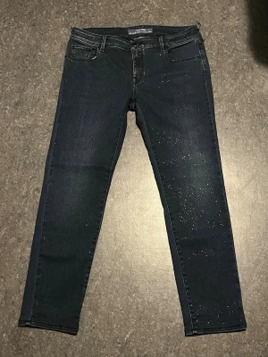 Jacob cohen jeans dam - Säljer Jacob Cohen jeans för dam. Jeansen är i fint skick förutom att en av bälteshällorna har gått upp. Byxorna har också stenar som gör att byxorna sticker ut. Byxorna är i storlek W/33. Hör av er vid funderingar eller om ni vill ha mått