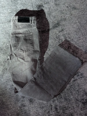 Flared jeans från boohooMAN, grå - Säljer ett par grå/svarta feta flared jeans från boohooMAN. Klassisk femficksmodell med bälteshällor och knappstängning. Jeansen har en rak passform upptill och lite utsvängda ben. Materialet är jeans och färgen är mörkgrå, perfekt för en chill och stilren look.