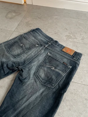 Vintage Nudie Jeans - Grim tim - Tja! Säljer nu mina galet feta Grim Tims, eftersom att dem inte sitter som dem gjorde förut. Helt otroliga och unika fades på dessa, så är med en tår i ögat jag släpper iväg dem || Storlek: 33/32 || Skick: 9/10 || Priset kan förhandlas, hör gärna av dig om du har frågor/vill ha fler bilder/annat!😁