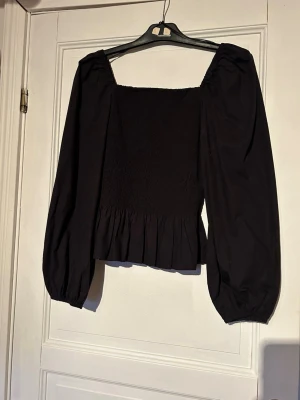 Svart blus med puffärmar - Säljer en svart blus med långa puffärmar. Använd fåtal gånger så i fint skick! 
