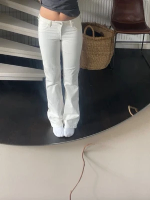 Vita bootcut jeans - Säljer ett par vita bootcut jeans från H&M i storlek 34. Byxorna har låg midja och utsvängda ben. 💗Innerbenslängden är 77cm och midjemåttet är 34cm rakt över 