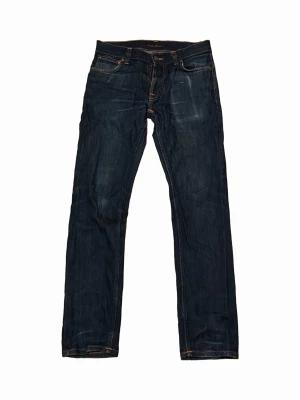 Nudie jeans raw denim W30/L30 - Säljer ett par nudie jeans i storlek W30/L30. Jeansen är raw denim och modell Thin Finn. Den har blivit lagad i skrevet av nudie.