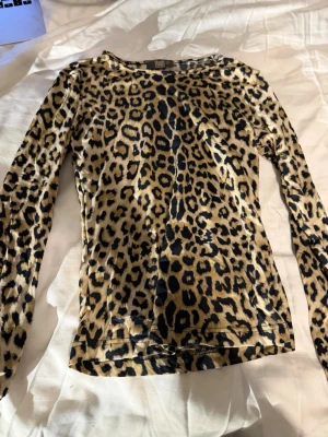 Leopardmönstrad topp🐆💫 - Säljer en snygg långärmad topp från Flash i storlek M med leopardmönster i brun,beige och svart. Toppen har rund hals och är figurnära i passformen. Materialet är mjukt och stretchigt, perfekt för dig som gillar att sticka ut med djurmönster.🐆💫
