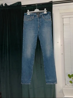 Levis 511 ljusblå jeans straight fit - Säljer ett par Levis 511 jeans i ljusblå tvätt med klassisk femficksdesign och raka ben. Jeansen har normal passform och är tillverkade i slitstarkt denimtyg av bomull. Perfekta för dig som gillar en enkel och tidlös look.