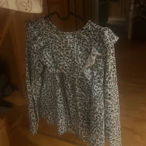 Blommig blus  - Blommig blus med volanger den är i storlek 164(13-14 år ) men den är ganska stor i storleken 