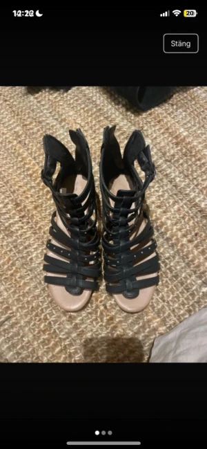 Svarta gladiatorsandaler från Zoey - Säljer ett par svarta gladiatorsandaler från Zoey i storlek 35. Sandalerna har flera smala remmar med små nitar, öppen tå och platt sula. Materialet är skinnimitation och de har en cool, edgy vibe som passar perfekt till sommarens outfits.