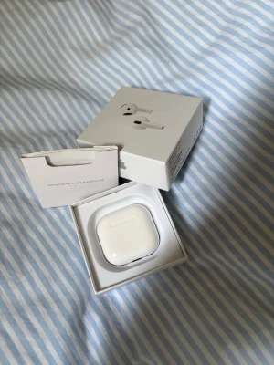 AirPods 4  - Säljer ett par AirPods 4 i originalförpackning med laddningsetui och manual. Hörlurarna är i mycket gott skick, inga synliga repor eller skador. Perfekt för trådlös musik och samtal med aktiv brusreducering. Levereras komplett som på bilderna.