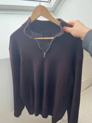Mörkbrun ribbad tröja Massimo Dutti - Säljer en mörkbrun ribbad tröja från Massimo Dutti med half zip och hög krage. Tröjan är långärmad och har en relaxed fit som passar perfekt till höst och vinter. Materialet är mjukt och stickat för extra komfort.